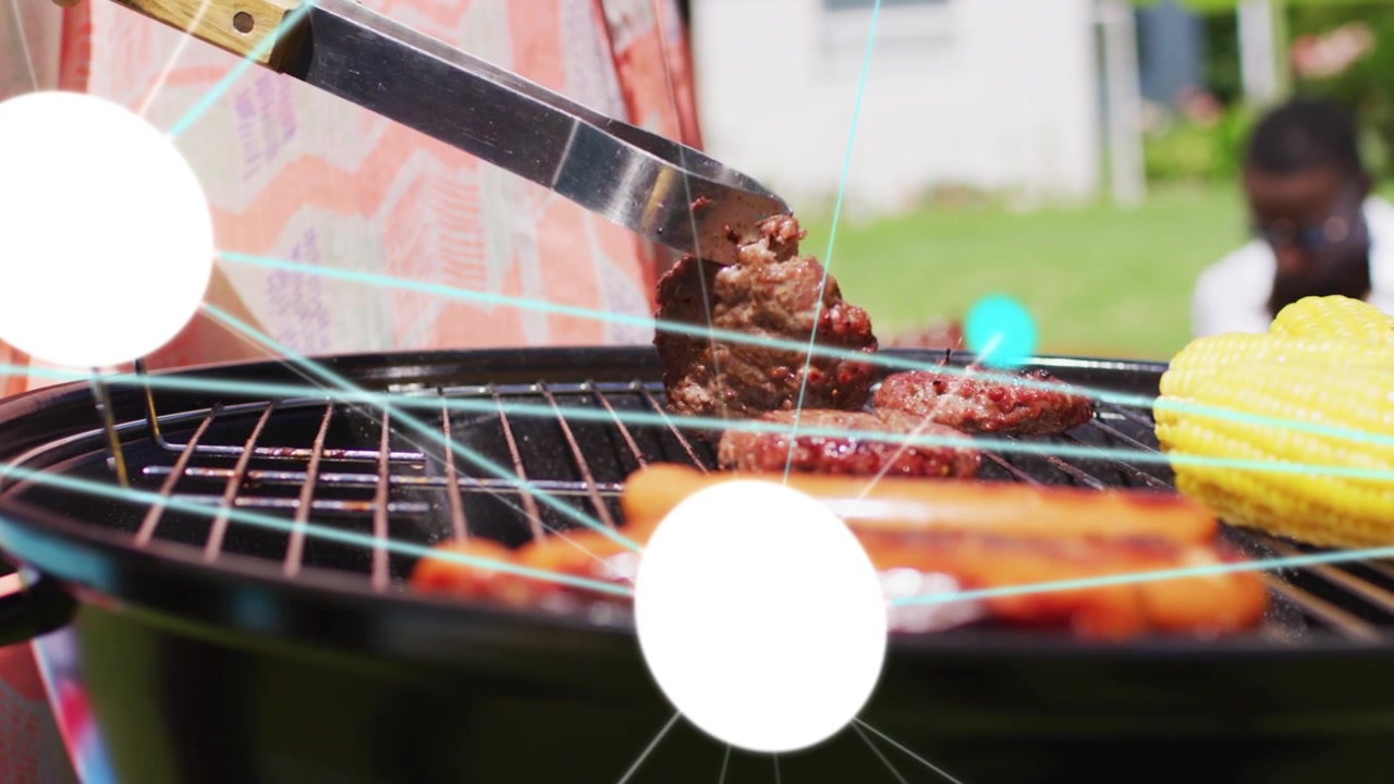 バーベキューでグリル担当者がトングを使ってハンバーガーを持ち上げてひっくり返し、焼き加減を示すアニメーションの点が表示されている。