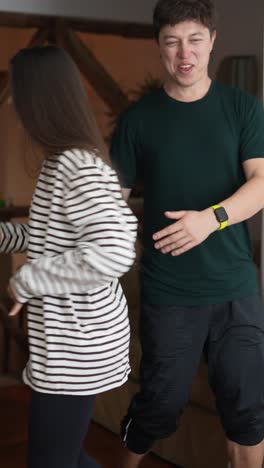 Couple holding hands and dancing in a living room