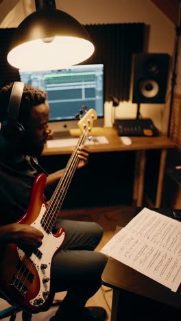 man playing bass guitar in a recording studio