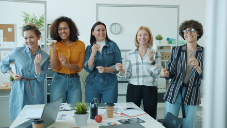 happy women dancing in the office