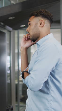 video of biracial businessman using smartphone and checking watch