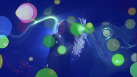 puntos brillantes multicolores de luces contra la mujer cantando en un concierto
