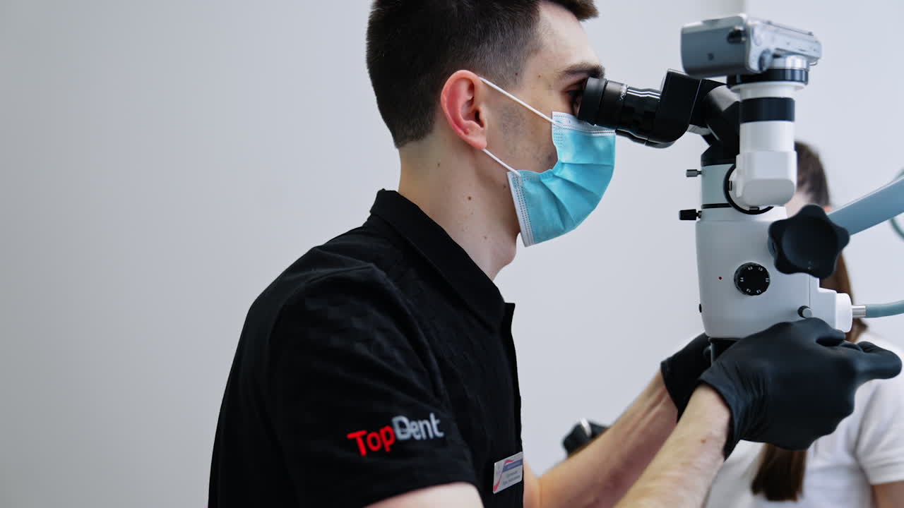 Dentist using microscope in dental office