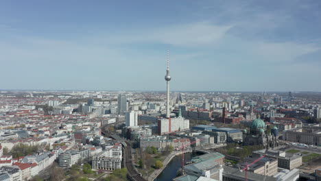 AERIAL:-Super-Close-Up-View-Circle-around-the-Alexanderplatz-TV-Tower-in-Berlin,-Germany-on-hot-summer-day