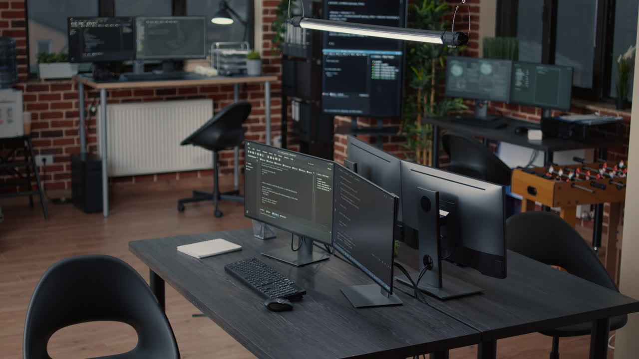 Computer screens running programming code in empty software it agency office and computers parsing data