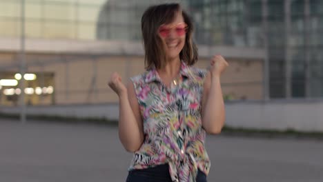 joyful tourist woman showing yes gesture with raised arms, excited about success celebrating victory