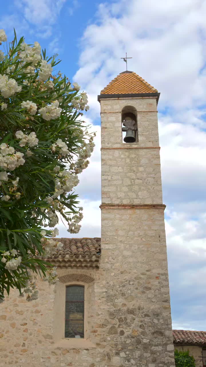 View of the Chapelle des Penitents Blancs Church with people walking near it. Vertical, Saint Paul de Vence, France