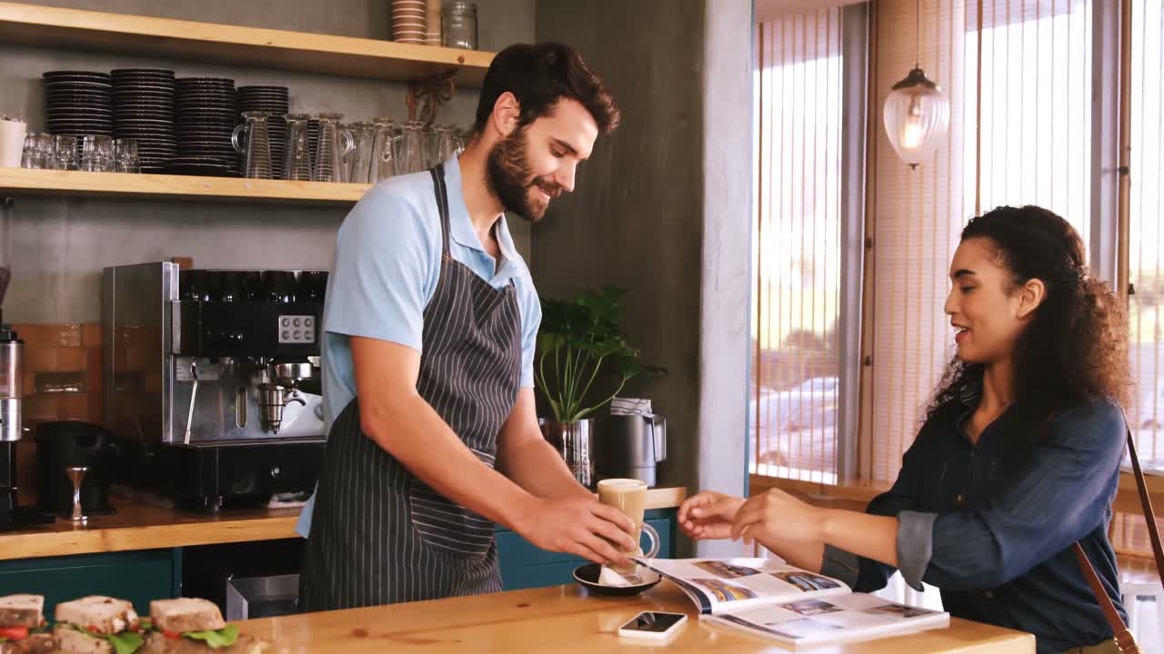 Smiling woman taking a coffee at table
