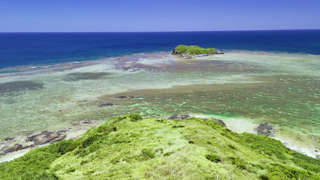 Luftoptagelse der flyver forbi det hvide Hirakubozaki Fyr for at afsløre en fantastisk turkis koral lagune og en lille klippeø ud for kysten af Ishigaki-øen, Japan