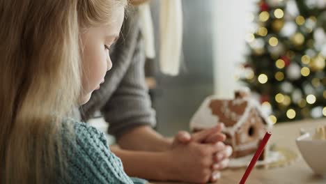 Handheld-video-of-little-girl-focused-on-writing-letter-to-Santa-Claus