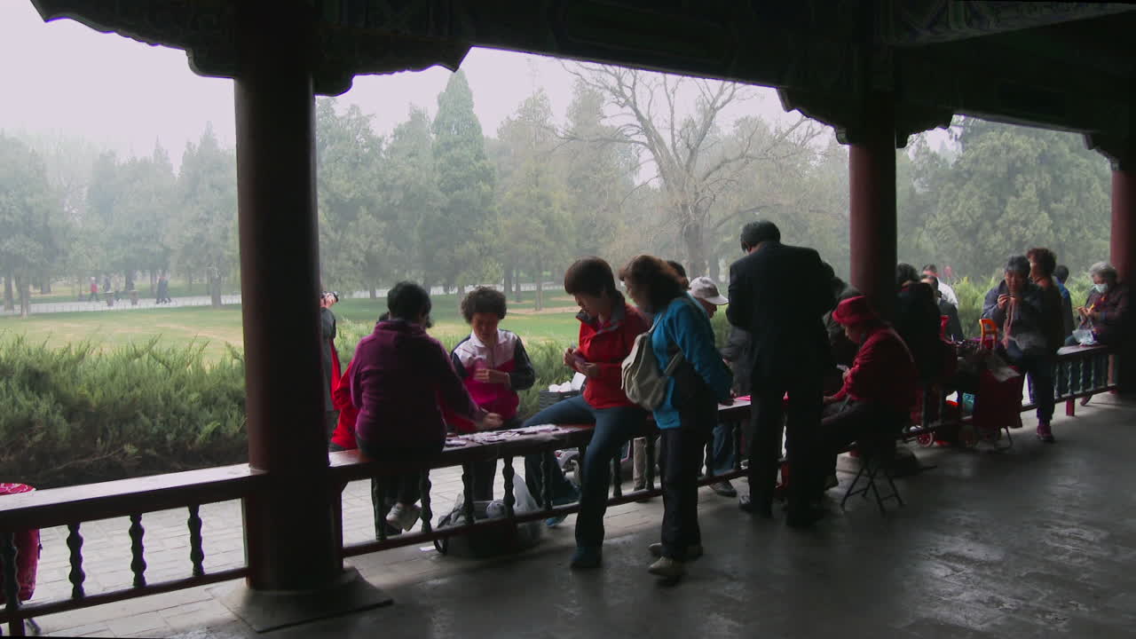 la gente juega a las cartas en un cenador en un parque en china
