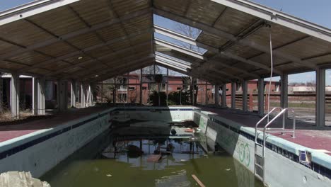 imágenes aéreas de drones rodando hacia atrás sobre una piscina cubierta abandonada