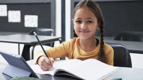 in a school setting, a young caucasian girl is writing in a notebook