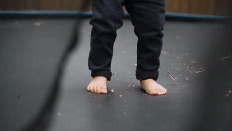 small boys bare feet jumping in super slow motion on a trampoline