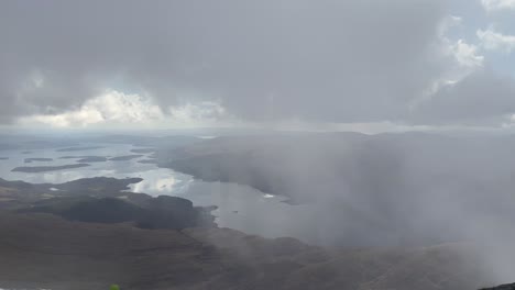 un lento panorámico sobre el lago lomond desde la cumbre de ben lomond munro en invierno.