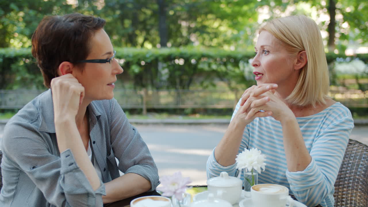 Two Women Enjoying Conversation in an Outdoor Cafe