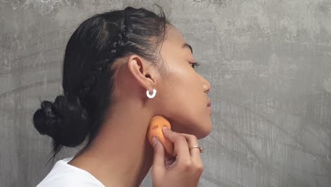 bonita chica asiática haciendo su propio maquillaje para una sesión de fotos.