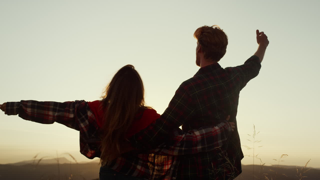 una pareja de excursionistas celebrando en la cima de la montaña