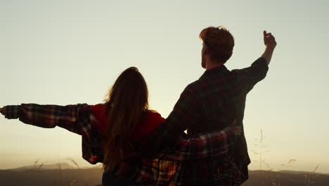 una pareja de excursionistas celebrando en la cima de la montaña