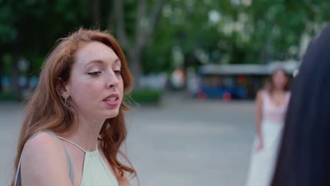 two women having a casual conversation outdoors in a park