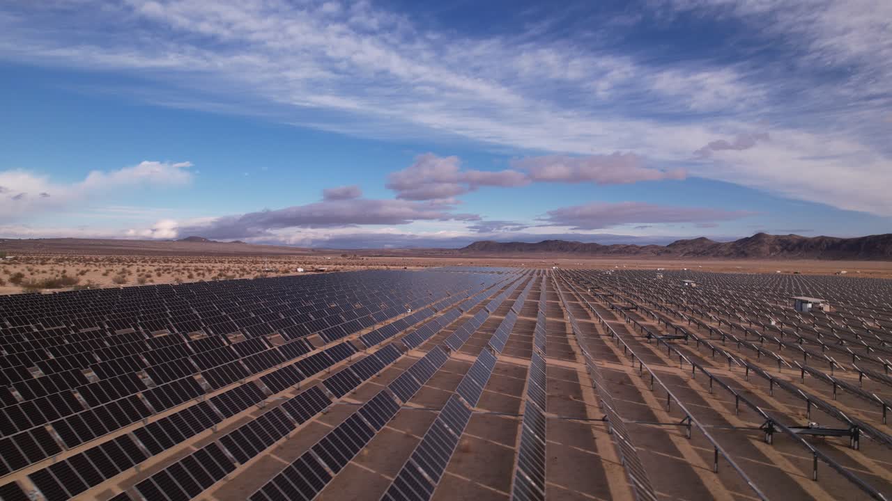 Droneoptagelser af solcellefelt i Joshua Tree Nationalpark på en solrig dag med regnbue i baggrunden, langsom horisontal bevægelse