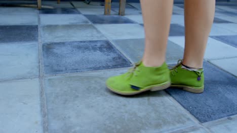 mujer con zapatos verdes caminando por el piso de baldosas 4k