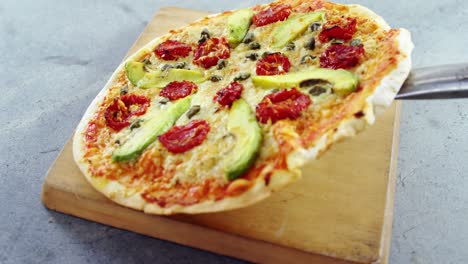 baked pizza served on wooden board