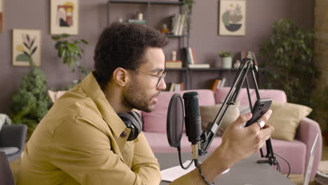 vista lateral del hombre grabando un podcast usando anteojos y auriculares 1