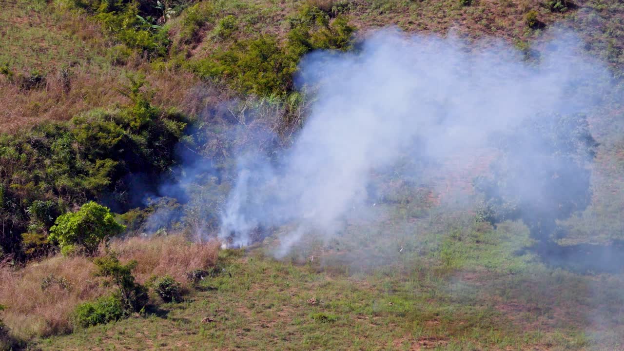 Haiti'nin kırsalında çevresel hasara ve ormansızlaşmaya yol açan kömür üretim sürecinin bir parçası olan duman çıkaran ateş. Havadan drone görünümü.