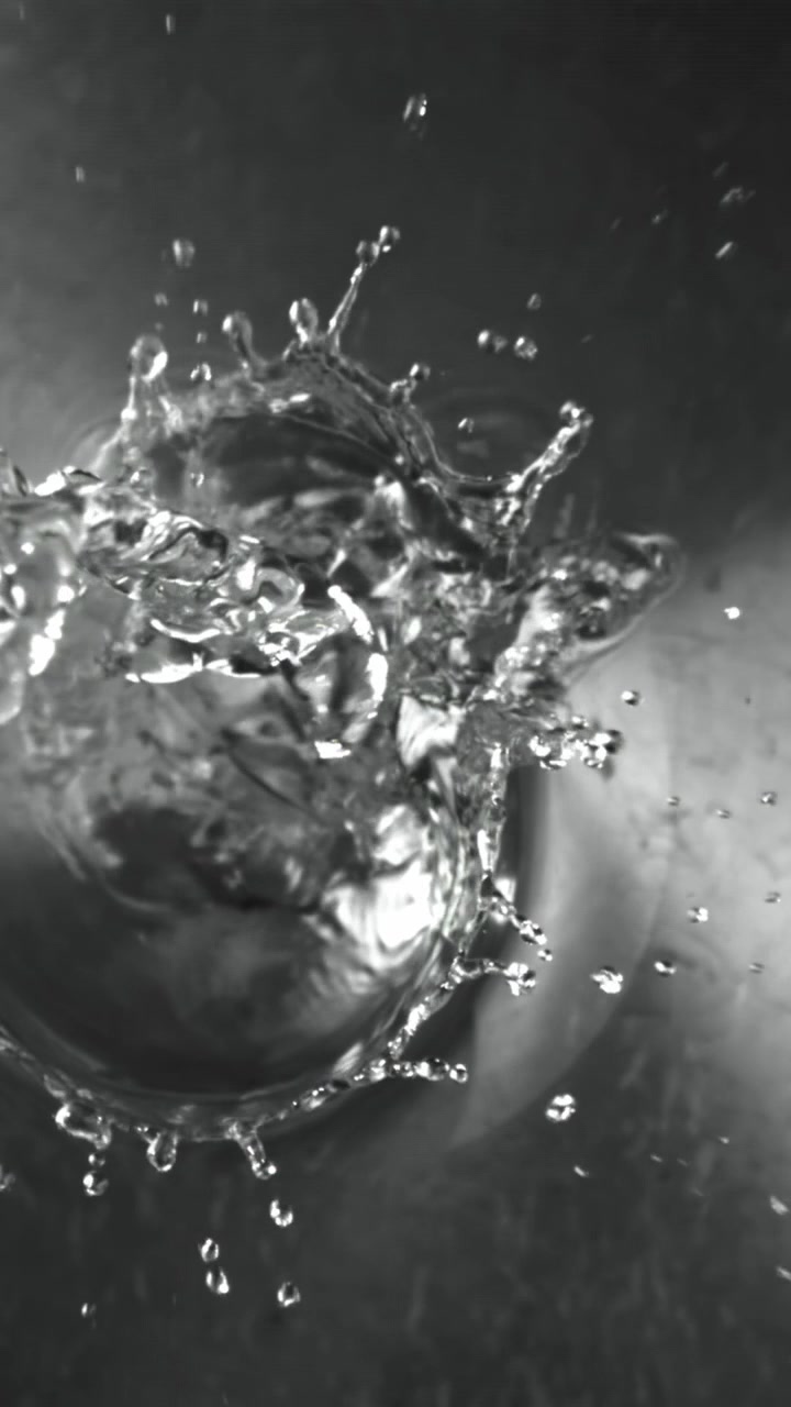 Slow Motion Close-Up of Water Splashing and Bubbling on a Metal Surface