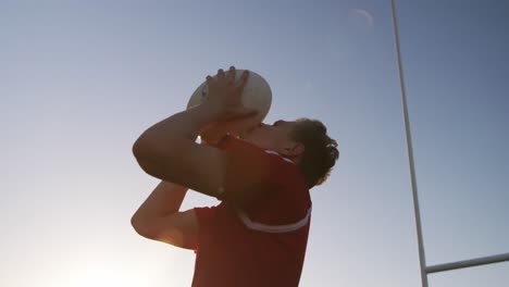 jugador de rugby besando la pelota de rugby