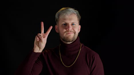 stylish friendly man feeling happiness, enjoyment, showing victory sign doing peace gesture, smiling