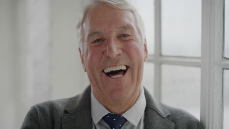 portrait-of-middle-aged-caucasian-man-laughing-enjoying-success-looking-at-camera-senior-male-retirement-standing-by-window-slow-motion