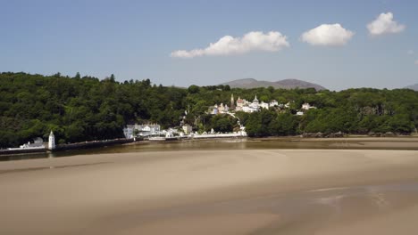 drone flying past portmeirion village on the dfyd estuary in north wales, britain, uk