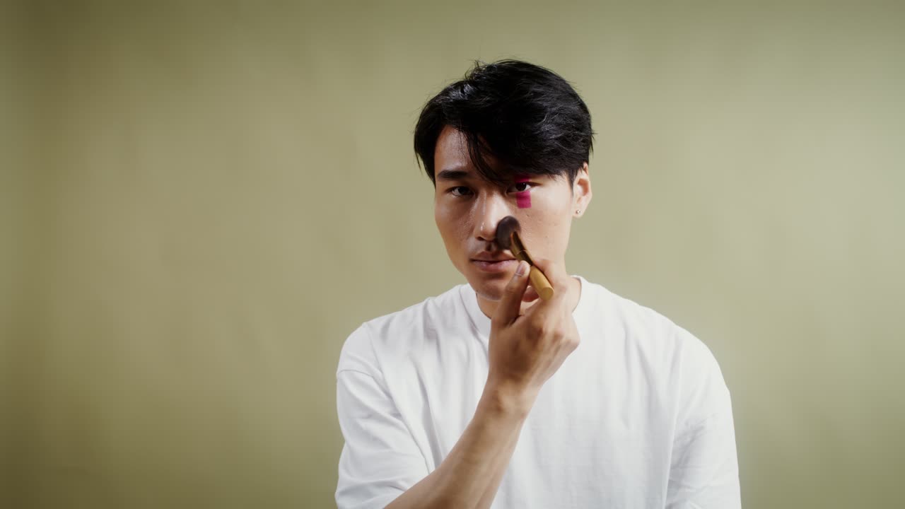 Man applying makeup with brush