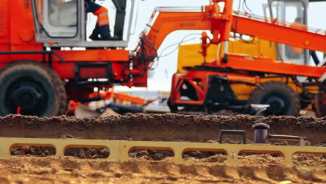 Große-Motorgrader-Ebnen-Den-Boden-Auf-Der-Baustelle.-Schwere-Maschinerie