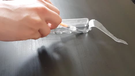 white caucasian young man giving an injection shot to himself into his arm