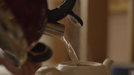 pouring water into a teapot