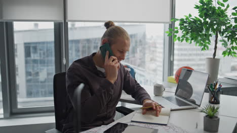 Hombre-De-Negocios-Ocupado-Hablando-Por-Teléfono-Celular-En-El-Interior-De-Cerca.-Chico-Positivo-Escribiendo-Notas