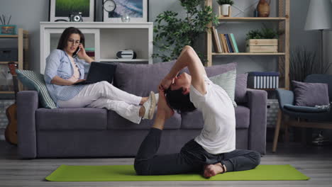 pareja practicando yoga en casa