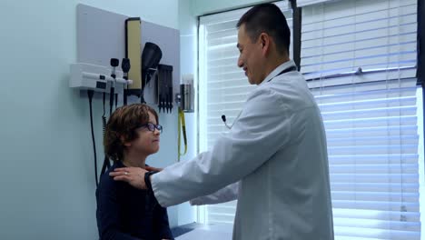 side view of young asian male doctor examining a caucasian boy patient in a clinic 4k