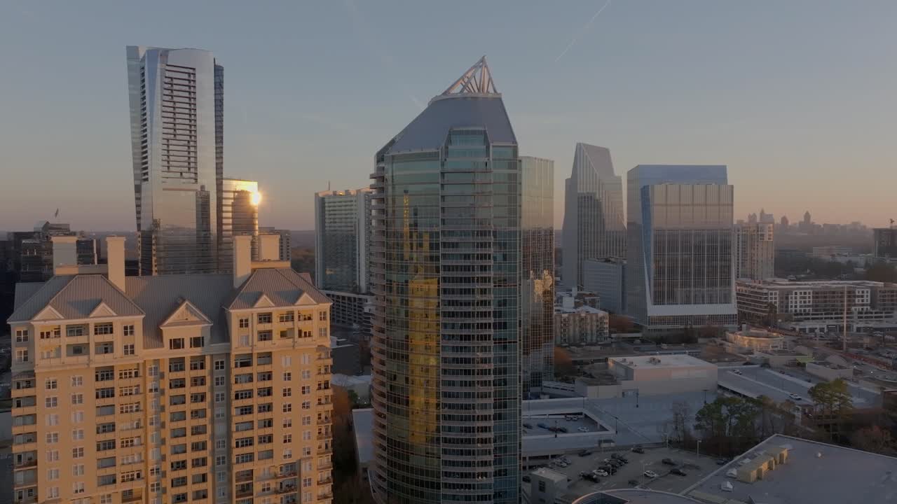 Drone shot reveals Buckhead business district, affluent neighbourhood with modern skyline buildings at sunset, Atlanta, Georgia