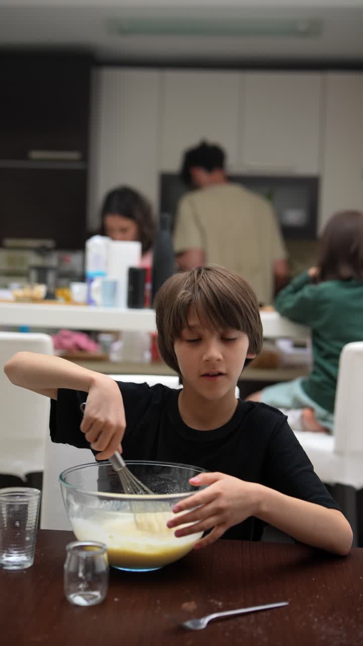 Bambino che cucina con la famiglia