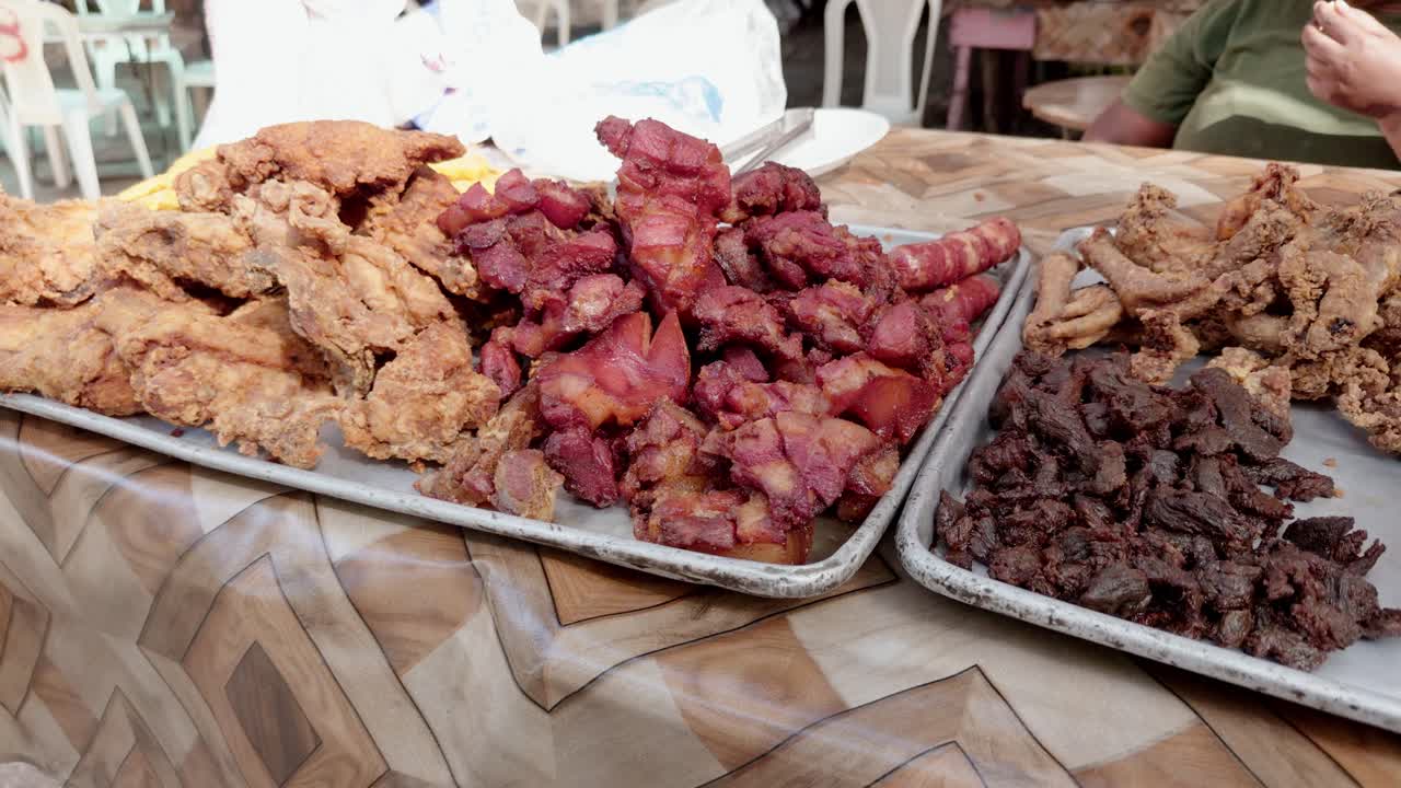 Fritura dominicana tradizionale con maiale fritto, pollo e altre carni, bancarella di street food a Neiba, Repubblica Dominicana. Primo piano