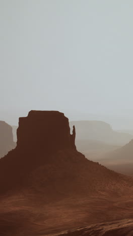 misty desert landscape with buttes