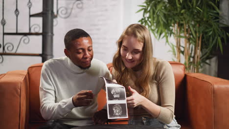 happy young couple looks at ultrasonic pictures of baby