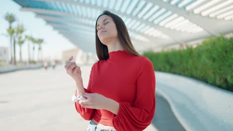 young woman listening to music at street