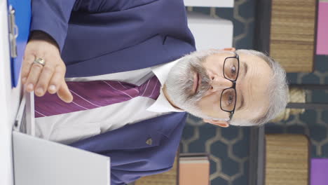 vídeo vertical de un viejo hombre de negocios mirando a la cámara con asombro y asombro.