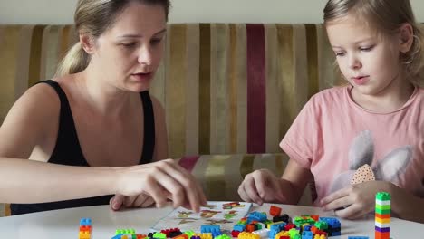 mother and daughter building with blocks