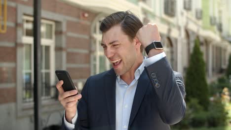 closeup business man receiving good news at street. man using smartphone outdoor